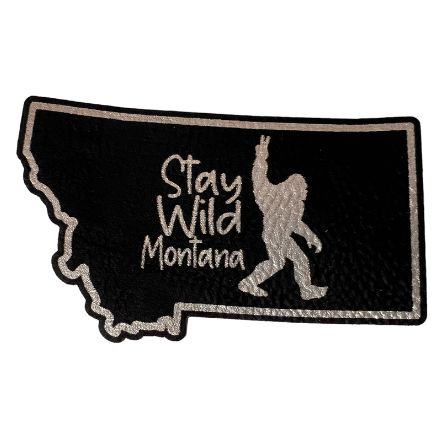A black and silver Montana-shaped patch with "Stay Wild Montana" lettering.