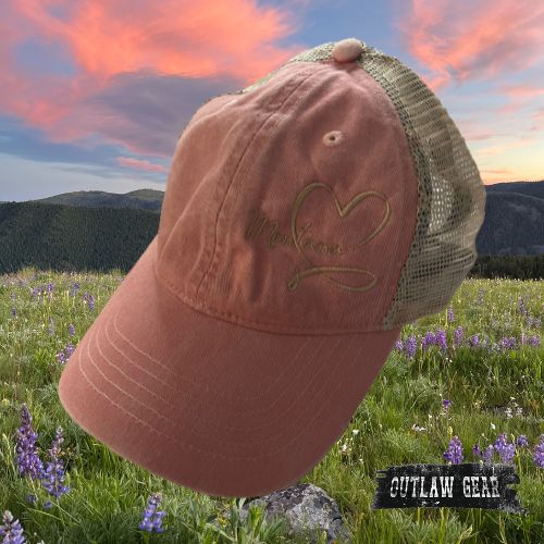 A dusty pink floral ponytail hat embroidered with "Montana Love," blending elegance and state pride in a charming accessory.