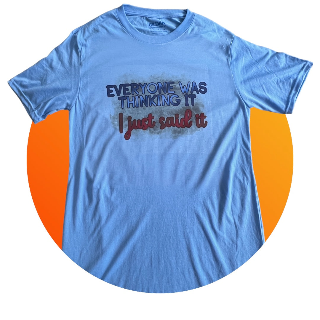 A performance T-shirt with the text "Everyone was thinking it. I just said it," perfect for adding humor and style to your wardrobe, featuring a thinking face emoji, smirking face emoji, and shrugging person emoji.