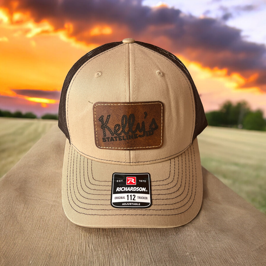 Image of the Kelly Hughes Stateline ID Richardson Cap with a dark brown patch, featuring the band's logo and an integrated ID slot, perfect for showcasing style and convenience at events with durable construction and a comfortable fit.