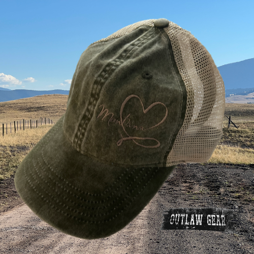 An embroidered olive camo ponytail hat adorned with "Montana Love," the perfect accessory for outdoor enthusiasts and state pride enthusiasts alike.