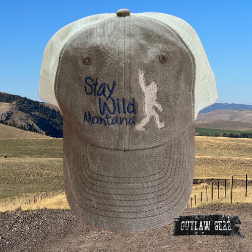 Image of the "Bigfoot Stay Wild Montana" Trucker Cap in Brown/Stone, featuring the iconic Bigfoot silhouette and the message "Stay Wild" embroidered on a stylish brown and stone color combination, perfect for adventurers and nature enthusiasts.